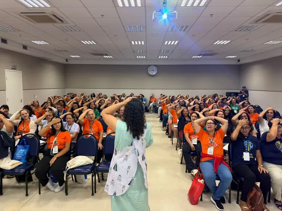 Carol Zabisky de costas conduzindo uma sala cheia de catequistas durante a Oficina Criativa